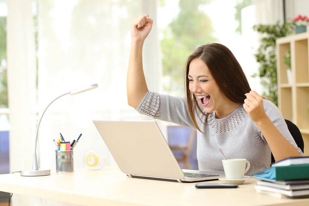 woman looking at her laptop and and smiling